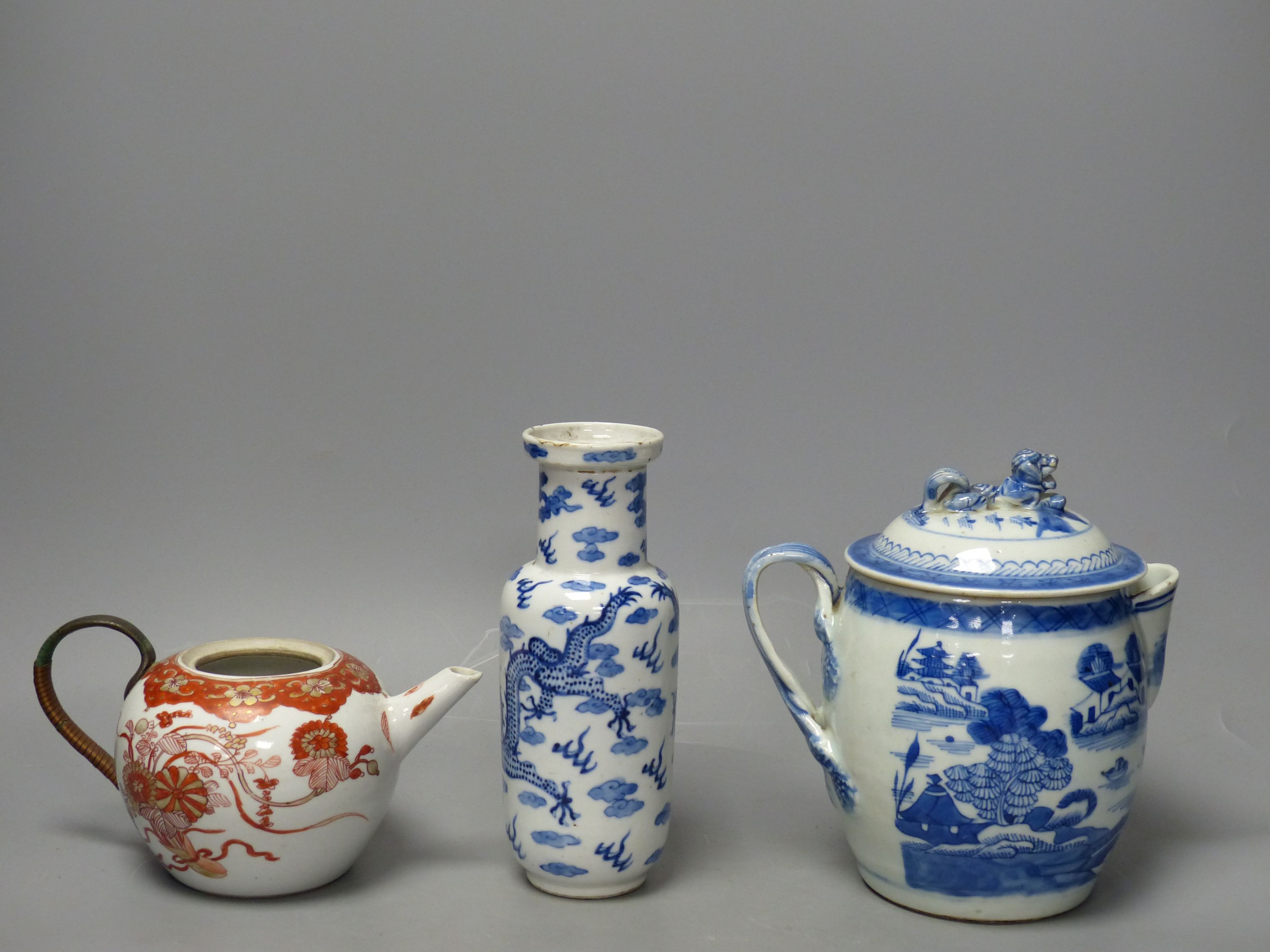 A 19th century Chinese blue and white covered jug, an early 20th century blue and white vase and a Kangxi rouge de fer teapot, tallest 18cm